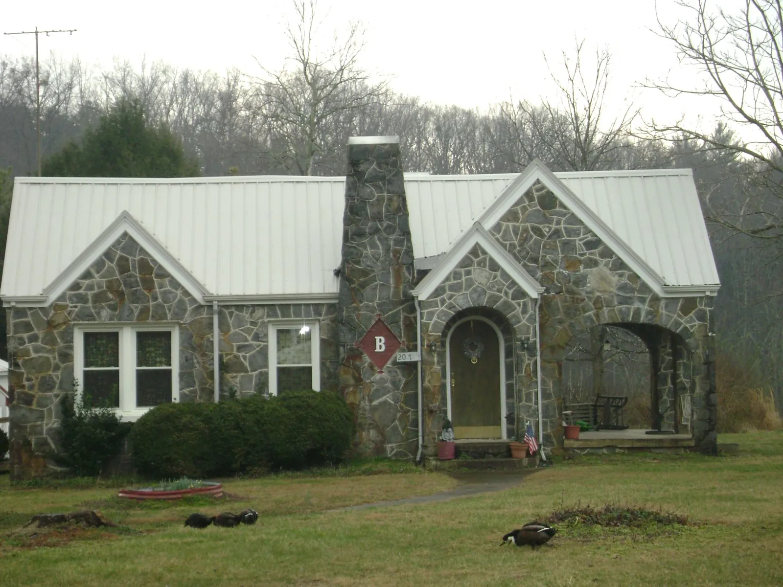 White metal roof on a stone cottage with steep gables in Montpelier